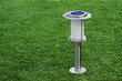 Solar-powered lamp on green grass background.