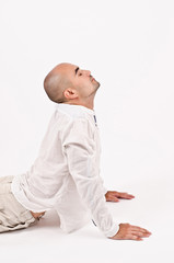 Wall Mural - Man dressed in white relaxing doing yoga and stretching.