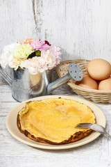 Sticker - Omelette on white wooden table, eggs in the background