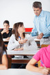 © Tyler Olson - Female Student Showing Paper To Teacher At Desk