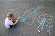 © laniko - Boy drawing house and tree with chalk