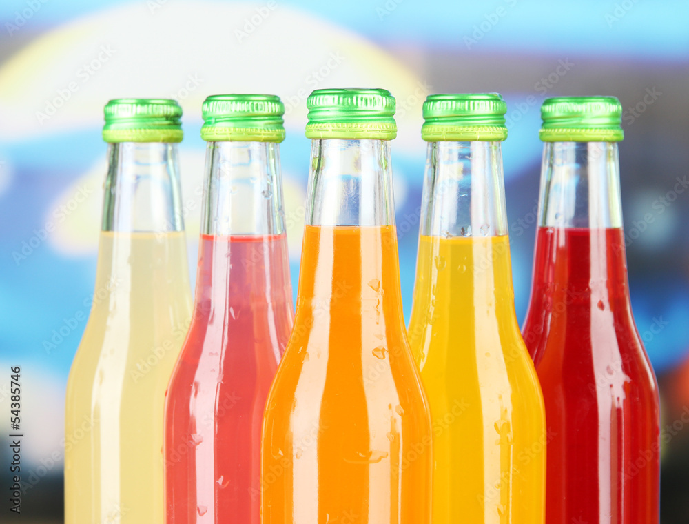 Bottles with tasty drinks on bright background