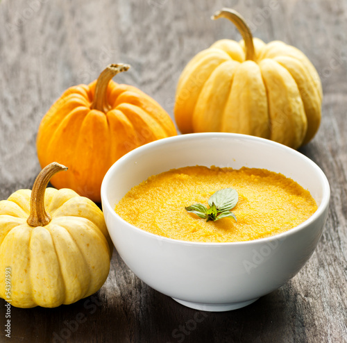 Nowoczesny obraz na płótnie Pumpkin porridge and pumpkins on black wooden table