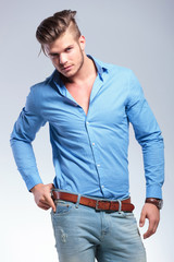 casual young man with hand on belt