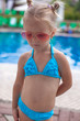 © travnikovstudio - Cute little girl standing alone near swimming pool