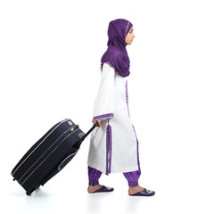 Muslim immigrant woman walking carrying a suitcase