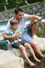 Wall Mural - Father teaching son how to fish in river