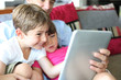 © goodluz - Father and children playing with tablet at home