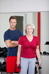 Canvas Print - seniorin mit trainer im fitnessstudio