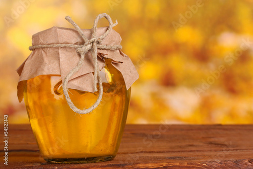 Plakat na zamówienie Jar of honey on wooden table on yellow background