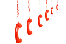 Isolated Dangling Red Retro Telephone Receivers On White