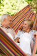 © CandyBox Images - Happy elderly couple in hammock