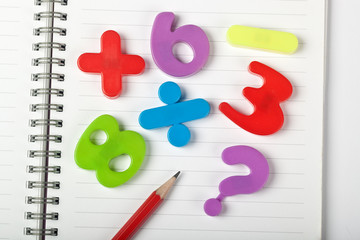 symbols of numbers and mathematical signs on a notepad