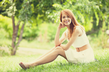 Poster - Redhead women lying at green grass