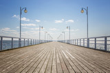 Fototapeta  - Old empty wooden pier over the sea shore with copy space
