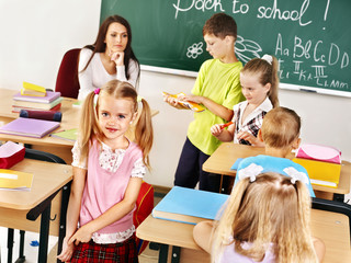 children in classroom near blackboard.