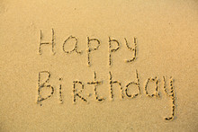 Inscription Happy Birthday On Texture Of Wet Sand.