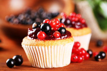 Canvas Print - Tasty muffins with berries on wooden table