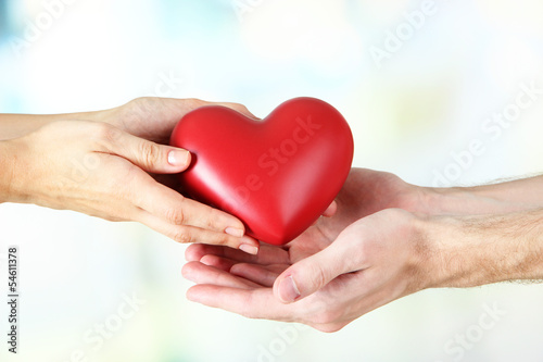 Fototapeta na wymiar Heart in hands on light background