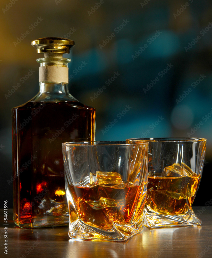 Glass of whiskey with bottle, on dark background