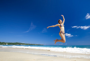 Wall Mural - Woman jumping on the beach