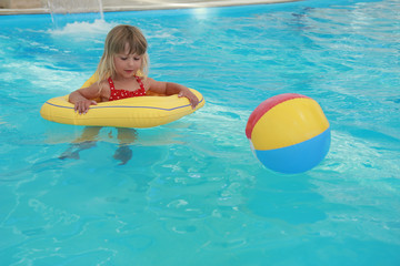 girl swims in a pool with a circle