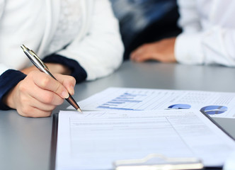 Businesswoman sitting at office desk signing a contract