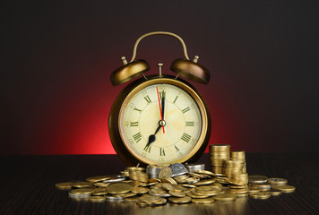 Wall Mural - Antique clock and coins on wooden table on dark color