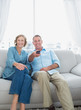 © WavebreakmediaMicro - Smiling middle aged couple sitting on the couch watching tv