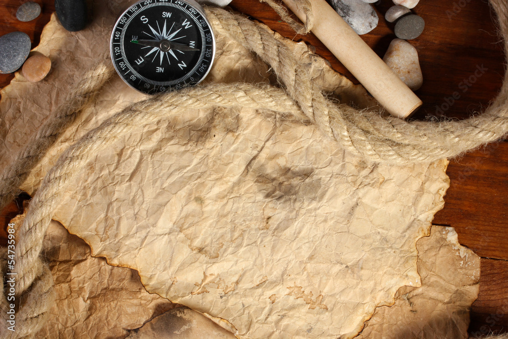 old paper, compass and rope on a wooden table