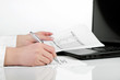 Female hand is writing in business document lying on the table