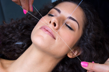 Canvas Print - woman on facial hair removal threading procedure