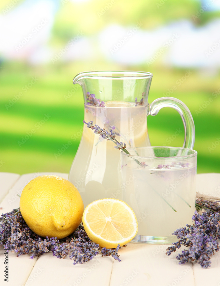 Lavender lemonade in glass jug, on bright background