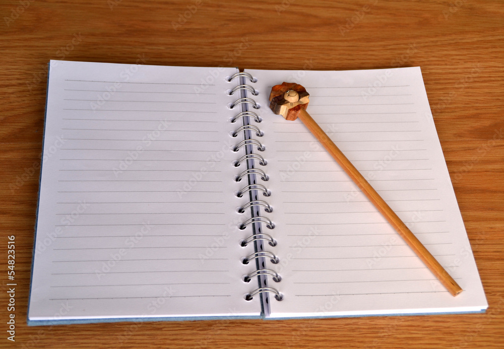 Foto de Stock Libreta y lápiz sobre escritorio de madera | Adobe Stock