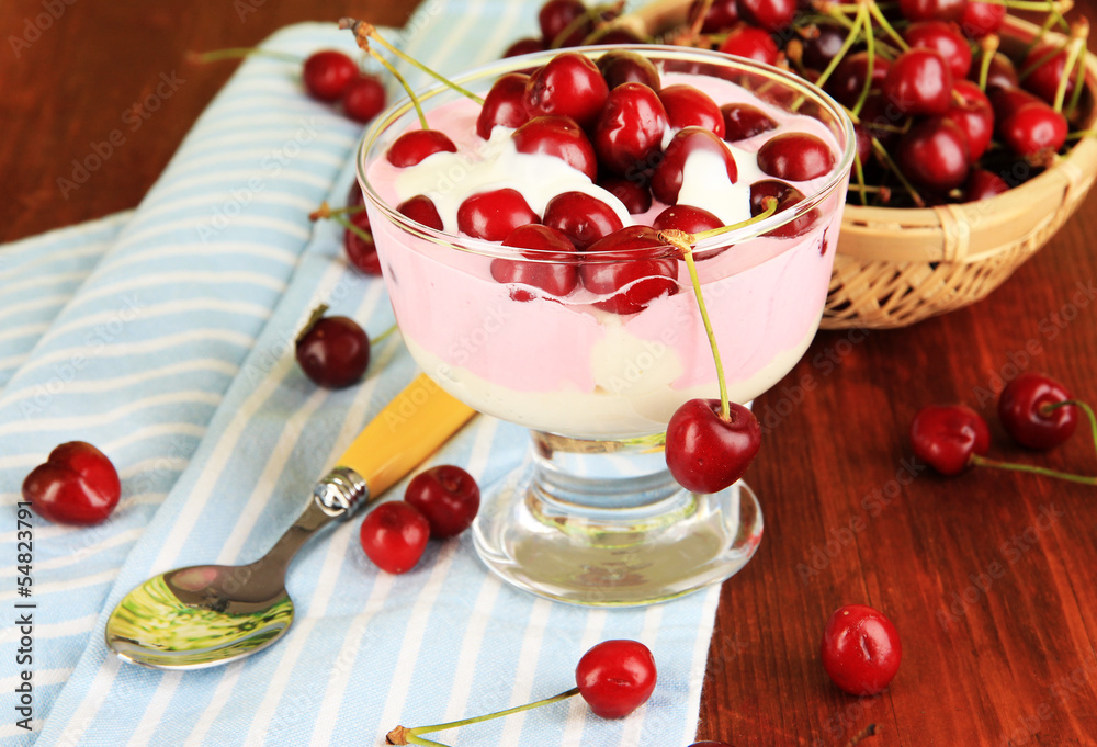 Delicious cherry dessert in glass vase on wooden table close-up
