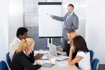 Wall Mural - Businesspeople Looking At Man Explaining