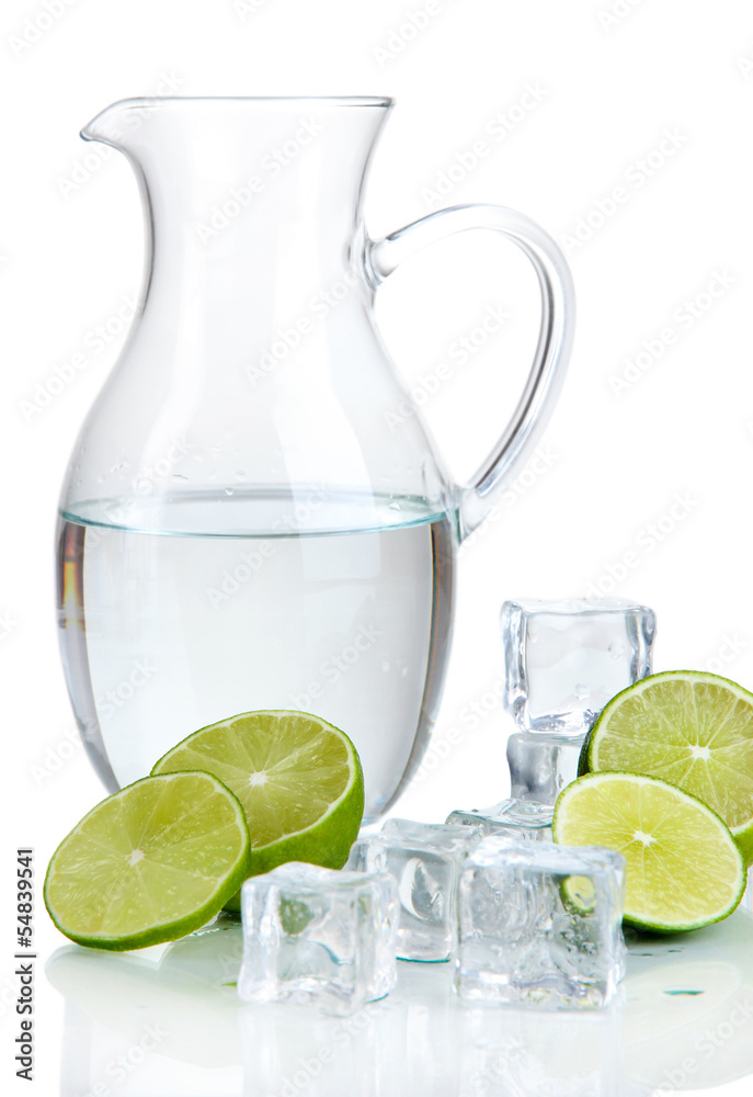 Glass pitcher of water with ice and lime isolated on white