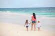 © travnikovstudio - Back view of young mother and her cute daughters walking along