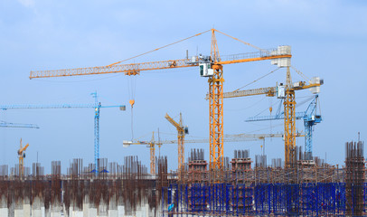 Wall Mural - Construction site with multiple cranes on a blue background.