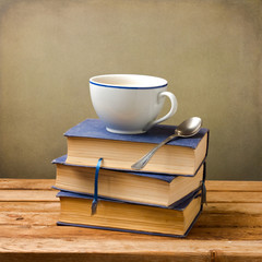 Wall Mural - Old books and cup of coffee on wooden table