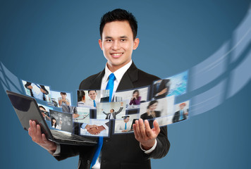 Wall Mural - Businessman sharing his photo and video files using laptop