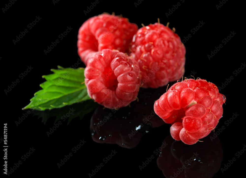 Ripe sweet raspberries with drops on dark background