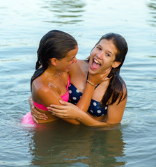 Wall Mural - Two teenage girls having fun in the river