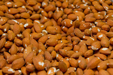 Heap of raw almonds nuts background