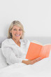 © WavebreakmediaMicro - Smiling woman sitting in bed reading