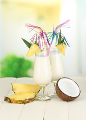 Wall Mural - Pina colada drink in cocktail glasses, on bright background