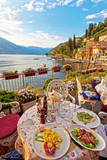 Fototapeta  - Romantic dinner scene of plated Italian food on terrace overlook