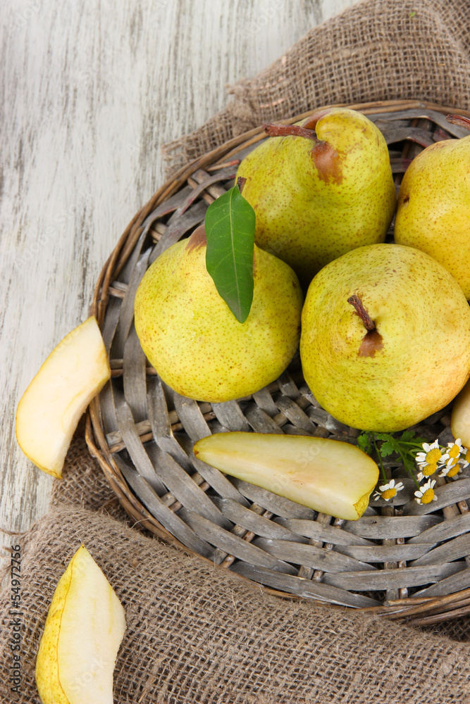 Pears on braided tray on burlap  on wooden table