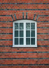 White Painted Wood Arched Window In A Red Brick Wall