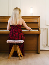 Blond Woman Playing The Piano At Home